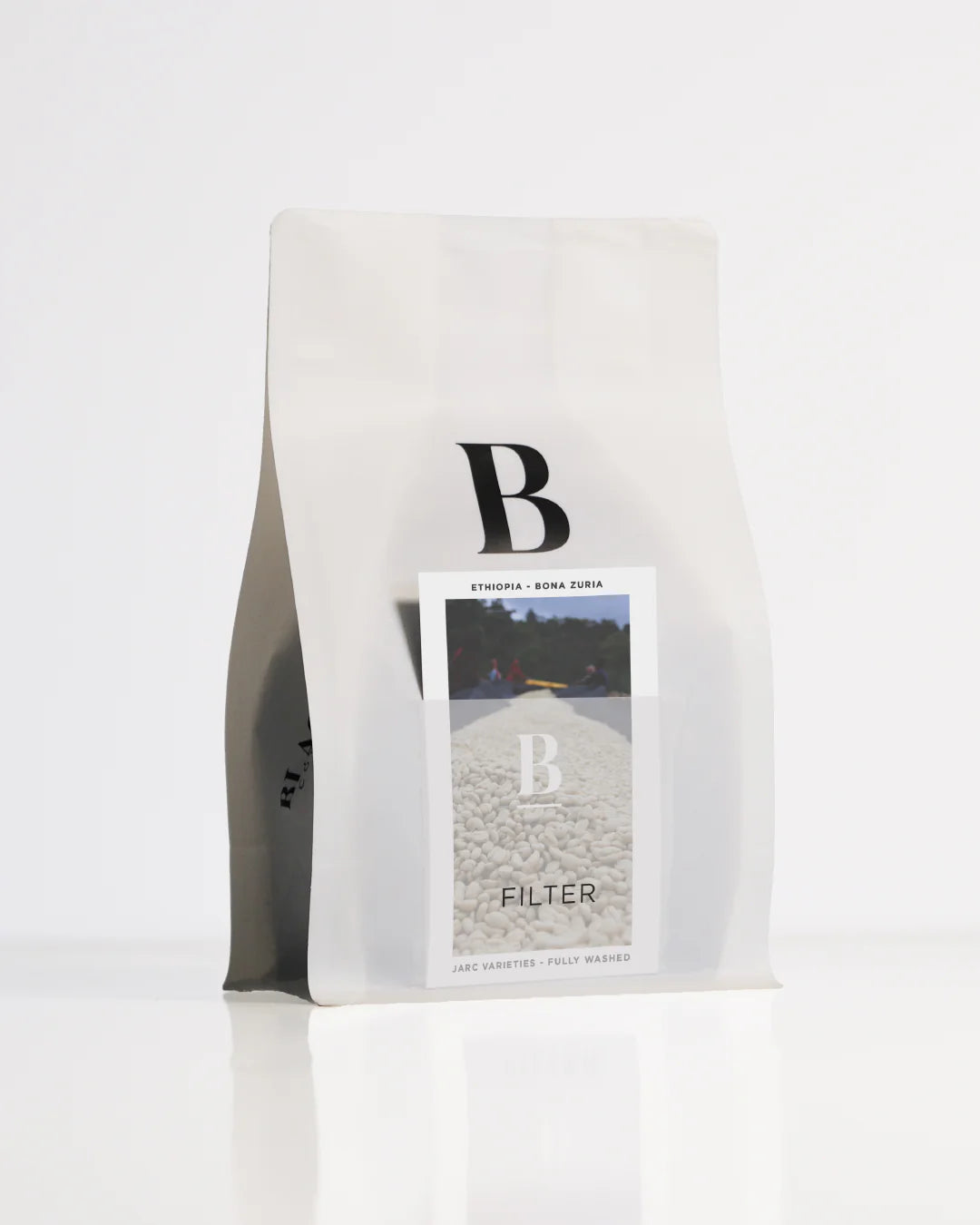 Roasted coffee beans. Blackboard Coffee Roasters, Roaster's Pick - Filter. Image shows a white 250g bag against a white background. The bag features the Blackboard logo and a pouch on the front with a product information card poking out. The Roast Collective.