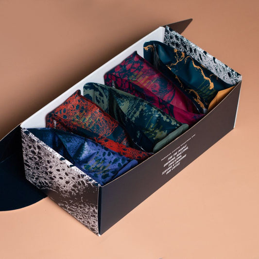 Roasted coffee beans from The Roast Collective. Paradox Coffee Roasters, All Blend Box. Image shows a 200g bag of each of Paradox's 5 espresso blends in a blue and white Paradox-branded box. The box is positioned at a right leaning diagonal angle in the image against a beige coloured background.