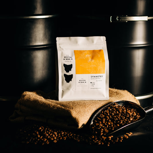 Roasted coffee beans The Boston Bean Coffee Co. Symmetry Blend 250g bag on coffee sack The Roast Collective