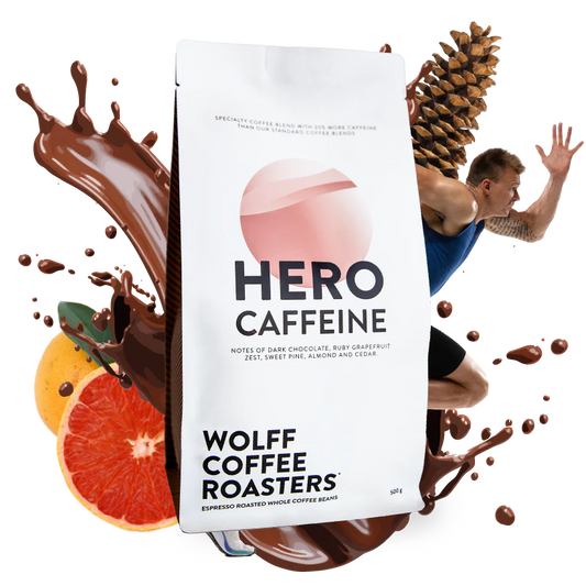Roasted coffee beans. Wolff Coffee Roasters Hero Caffeine Blend, 500g bag with fruit, chocolate, pinecone, and a man in background. The Roast Collective