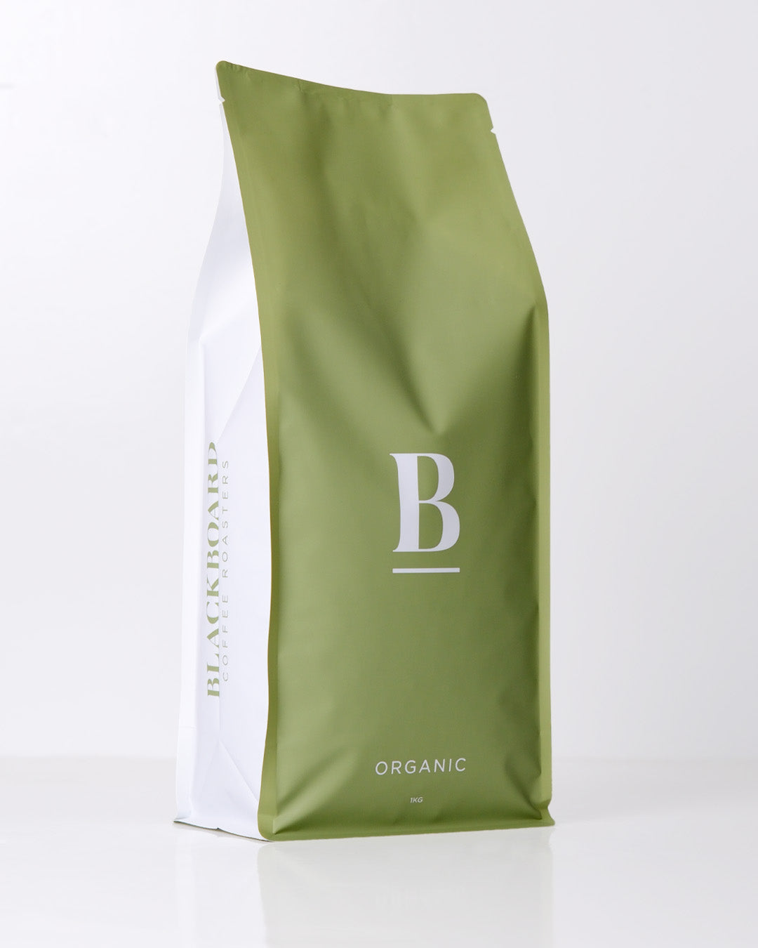 Roasted coffee beans. Blackboard Coffee Roasters, Blackboard Organic Espresso Blend. Image shows a green and white coloured 1kg bag against a white background. The bag features the Blackboard logo centred in the middle of the bag and the blend name centred at the bottom. The Roast Collective.