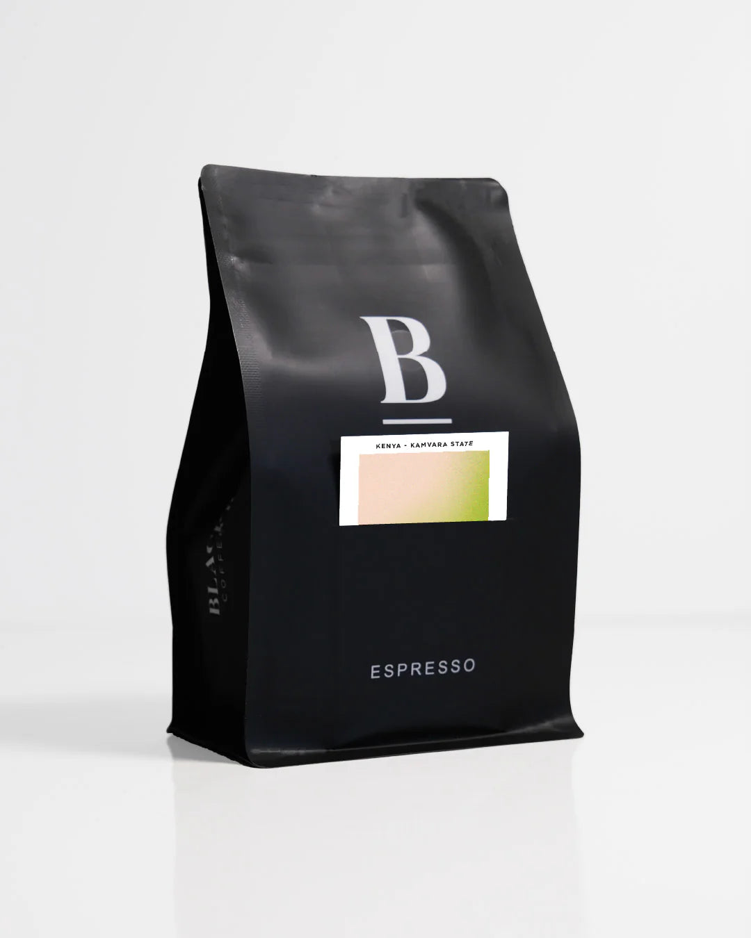 Roasted coffee beans. Blackboard Coffee Roasters, Roaster's Pick Espresso. Image shows a black 250g bag against a white background. The bag features the Blackboard logo and a pouch on the front with a product information card poking out. The Roast Collective.