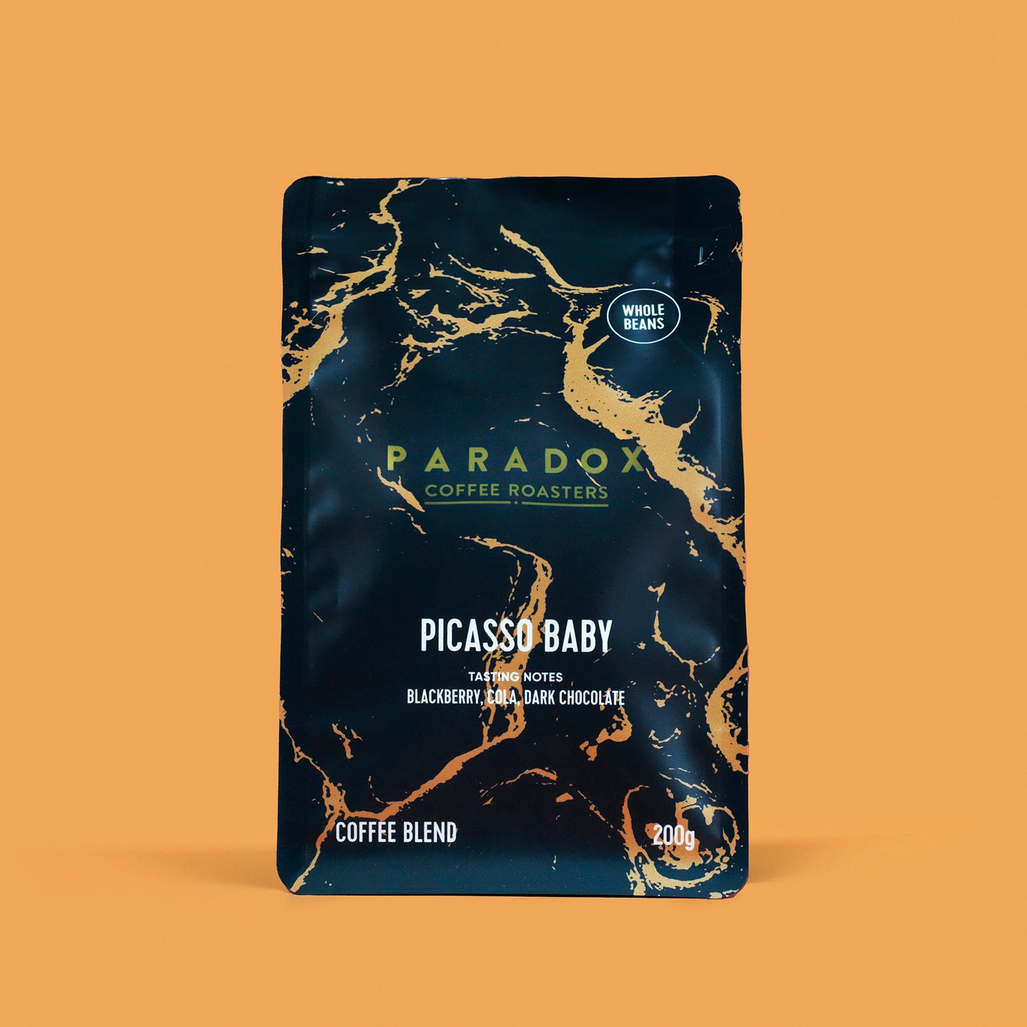 Roasted coffee beans from The Roast Collective. Paradox Coffee Roasters, Picasso Baby Blend. Image shows a 200g bag of the coffee against a nugget yellow coloured background. The bag is two-tone in colour, with navy blue and gold arranged in a geological print. Paradox's logo is centred in the top half of the bag, with the blend name, tasting notes and weight underneath. 