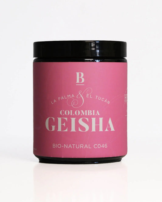 Roasted coffee beans. Blackboard Coffee Roasters, May 2025 Special Reserve - Colombia, La Palma Y El Tucan, bio-natural gesha. Image shows a black 100g glass jar against a white background. The jar features a pink wraparound label that covers most of the side of jar. The label has the Blackboard logo centred at the top, with the product's name styled underneath and the 'bio-natural c046' process underneath. The Roast Collective.