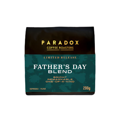 Roasted coffee beans from The Roast Collective. Paradox Coffee Roasters, Limited Release Father's Day Blend. Image shows a black 200g bag of the coffee against a white background. The bag has Paradox's logo centred at the top of the bag in gold coloured print and a green camouflage pattern label centred on the lower half of the bag with the product name, tasting notes, roast profile and weight on it.