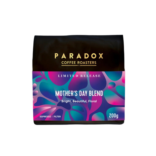 Roasted coffee beans. Paradox Coffee Roasters - Limited Edition Mother's Day Blend. Omni-roast: suitable for espresso and filter. Image shows a 200g bag against a white background. The Roast Collective.