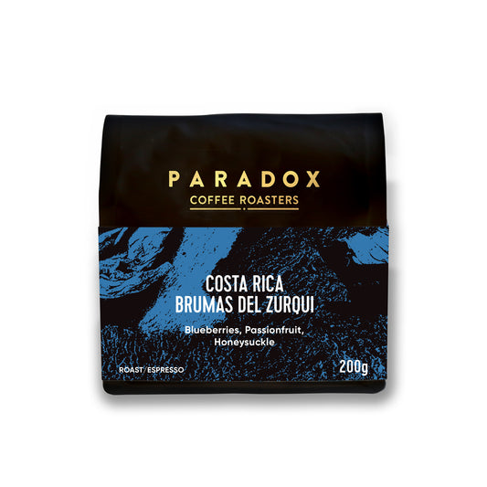 Roasted coffee beans. Paradox Coffee Roasters, Colombia - Brumas del Zurqui. Espresso roast only. Image shows a 200g bag against a white background. The Roast Collective.