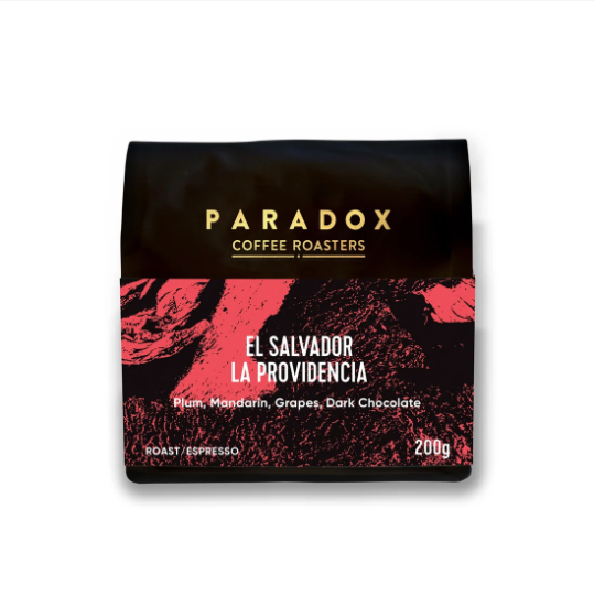 A 200g bag of Paradox Coffee Roasters 'El Salvador La Providencia' espresso, featuring a black bag with gold lettering and a red and black textured graphic on the lower half.